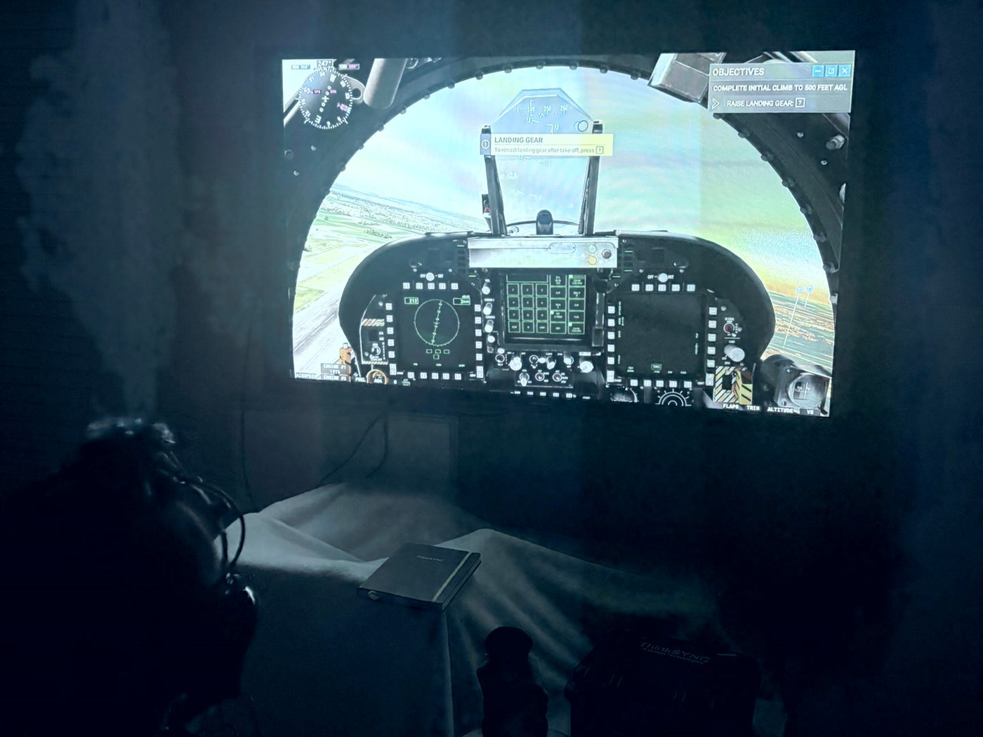 A student flying a simulator session in a darkened room, wearing the ThinkSYNC headset.