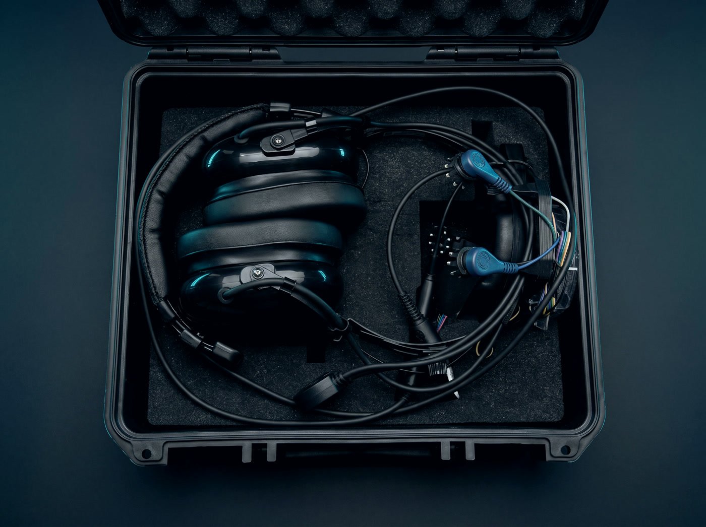 The case open, showing the aviation headset and the electrode harness in cut foam.